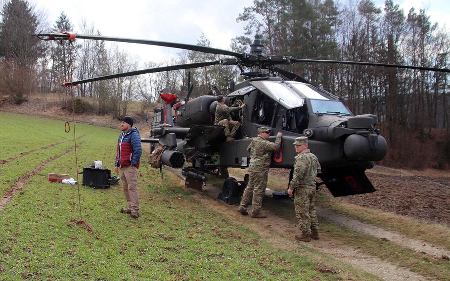 U.S. soldiers work on an AH-64 Apache helicopter March 18, 2021, in a field in Moritz, an area near Goessweinstein, about about 30 miles west of the Grafenwoehr Training Area, Germany. The Apache from the 12th Combat Aviation Brigade made a precautionary landing in the field March 17 after an indicator light came on in the cockpit.

