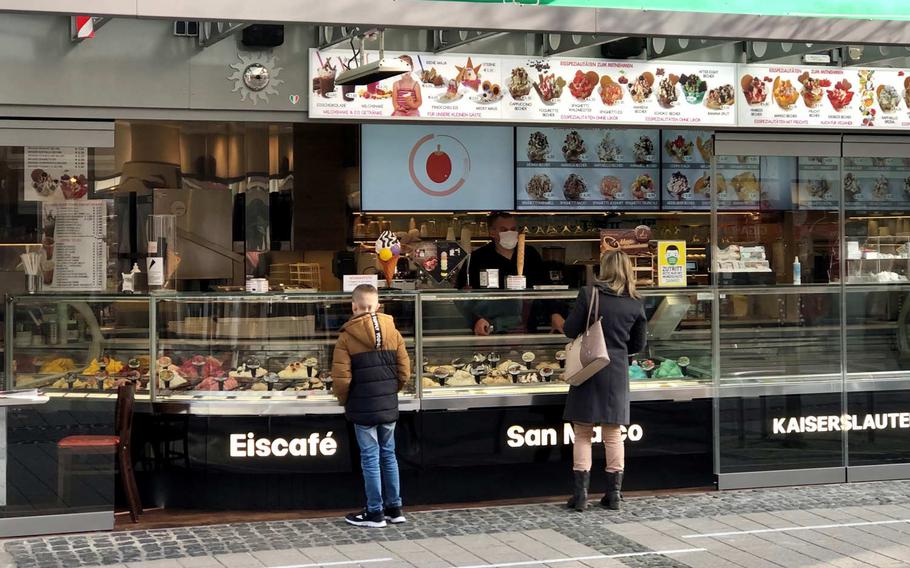 Customers order ice cream from a cafe in the pedestrian district of Kaiserslautern, Germany, March 23, 2021. The German government and the states announced plans to impose a short, sharp lockdown during Easter week, to stem the rising number of coronavirus cases in the country.
