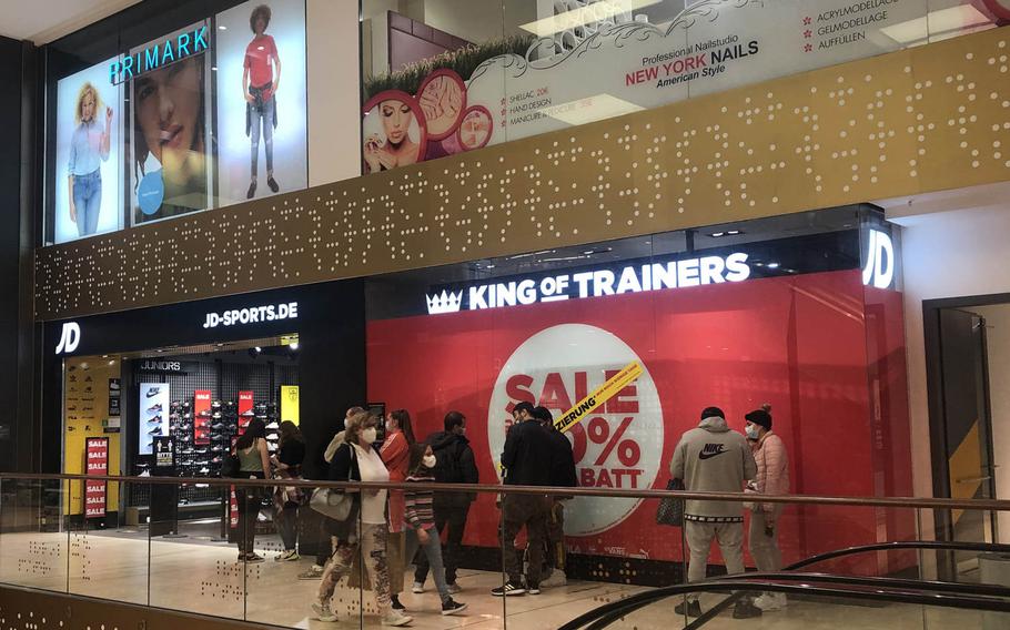 People wait to enter a sports shop in the K in Lautern mall in Kaiserslautern, Germany, on Monday, March 29, 2021, hours before coronavirus restrictions on shopping in the district were due to take effect, following a spike in new infections.