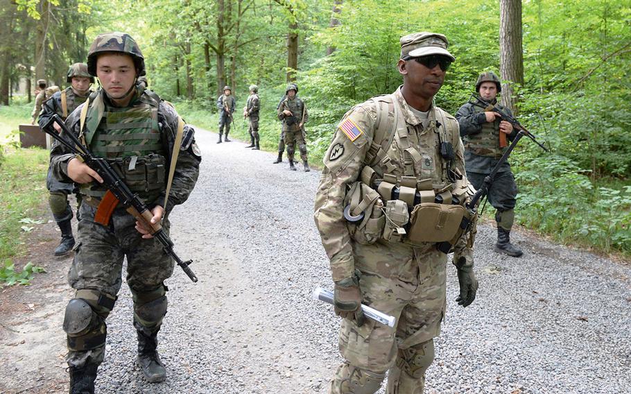 U.S. Army Staff Sgt. Gregory Simmons, center, supervises Ukrainian national guardsmen on a simulated patrol in July 2015, at a training facility in Yavoriv, Ukraine. A rapid Russian military buildup along the Ukrainian border in recent weeks has sparked fears of an invasion.