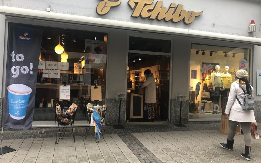 A customer waits outside as a woman pays for coffee at the Tchibo store in Kaiserslautern on April 19, 2020. The store was allowing in one customer at a time as new coronavirus infections surged in the area.

