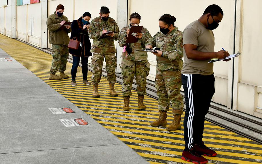 U.S. airmen and dependents fill out paperwork prior to receiving COVID-19 vaccinations at Aviano Air Base, Italy, April 23, 2021.

