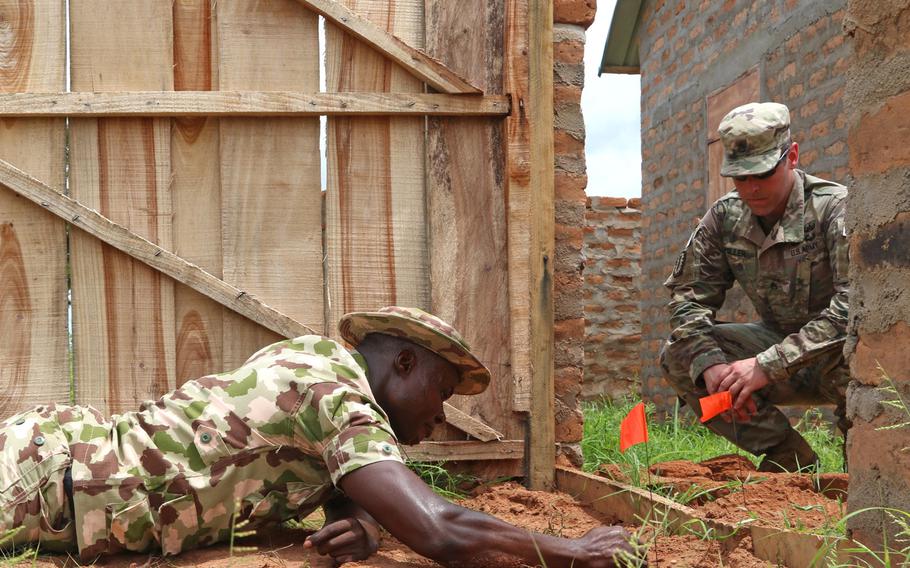 U.S. Army Staff Sgt. Brian Miller, an explosive ordnance technician, watches while a Nigerian soldier searches for a potential explosive during training at the Nigerian Army School of Military Engineers in Makurdi, Nigeria in May 2019. The country's president, Muhammadu Buhari, asked U.S. Secretary of State Antony Blinken during a virtual meeting April 27, 2021, to move U.S. Africa Command headquarters to Africa.

