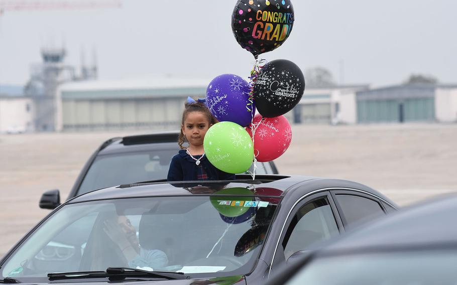 A girl makes a face while getting a good view through a vehicle sun roof of commencement festivities for the University of Maryland Global Campus Europe class of 2021 on Saturday, May 1, 2021, in Wiesbaden, Germany.
