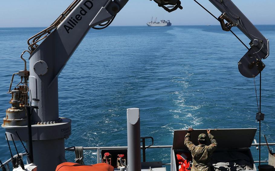 A U.S. soldier from the 259th Transportation Battalion works on the deck of the U.S. Army Logistics Support Vessel MG Charles P. Gross, with the USNS Bob Hope seen in the background April 26, 2021, near the coast of Durres, Albania, as they prepare for exercise Defender-Europe 21. 