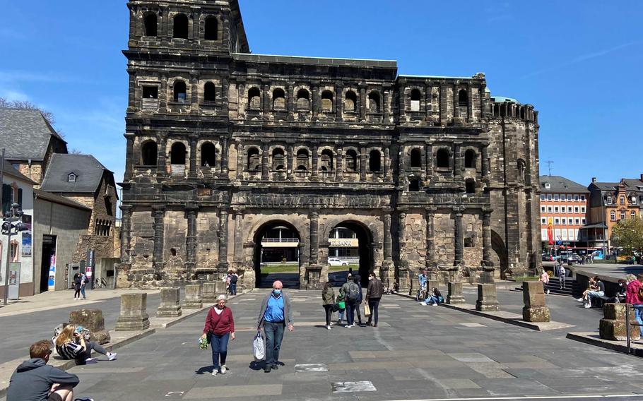 People stroll in front of the Porta Nigra, an ancient Roman city gate, in Trier, Germany, April 24, 2021. Rheinland-Pfalz, home to tens of thousands of U.S. personnel, is relaxing restrictions in areas with low incidence rates of the coronavirus. Trier, with a weekly incidence of 37.7 new cases per 100,000 residents, has the lowest rate in Rheinland-Pfalz.

