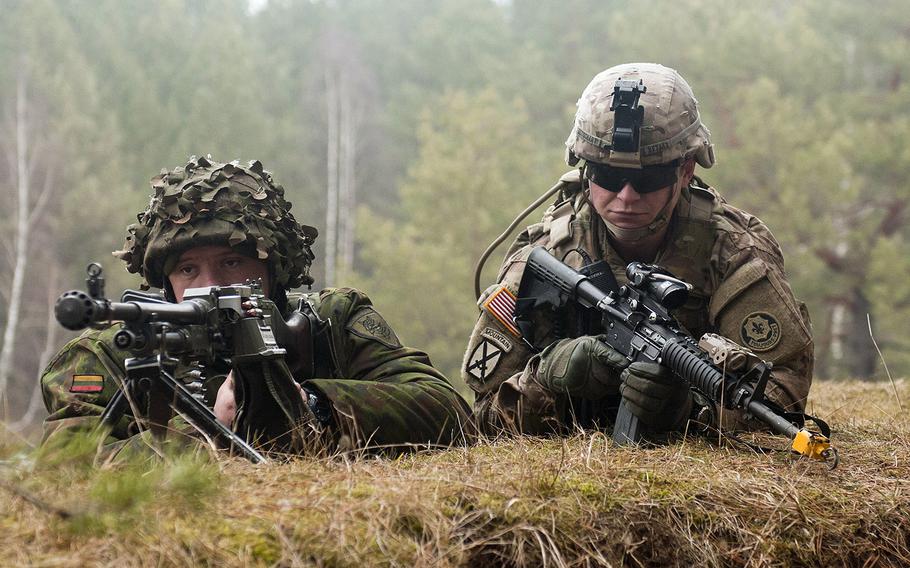 Spc. Shawn Betschart, right, of the 2nd Cavalry Regiment, secures the perimeter with a Lithuanian counterpart during an exercise in Lithuania in 2015. Lithuania's Defense Ministry said this week that the coronavirus pandemic has created conditions for disinformation campaigns aimed at discrediting the NATO alliance to grow.
