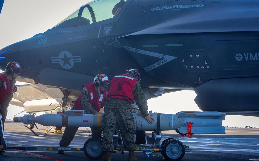 Cpl. Charlton Hale, Sgt. Cody Jackson and Lance Cpl. Hunter Soileau transport Guided Bomb Unit 12 Paveway II’s to an F-35B Joint Strike Fighter on the flight deck of the British aircraft carrier HMS Queen Elizabeth while at sea, Sept.29, 2020. 

