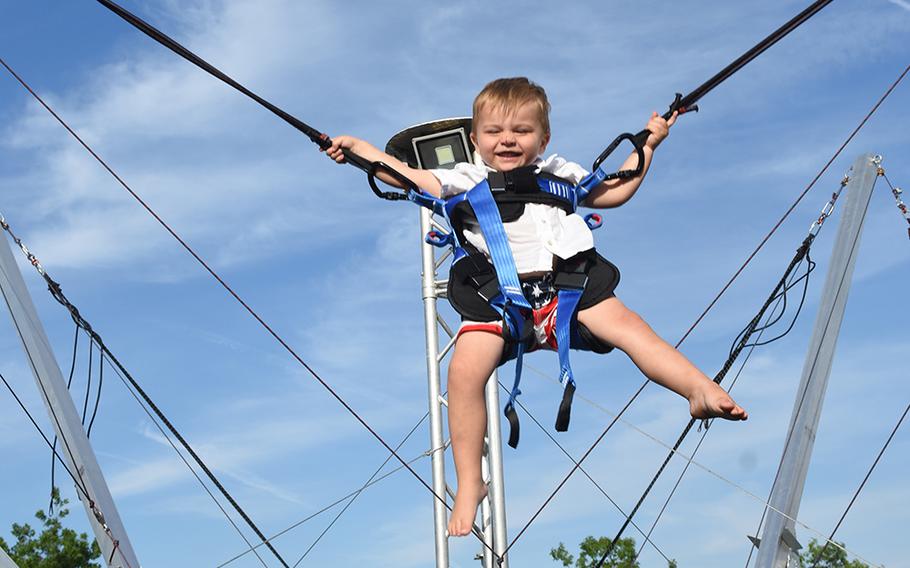 Rowdy Webster, 2, giggles as he flies high on a trampoline-like device called the Beach Jump at the Freedom Fest at Ramstein Air Base, Germany, on July 3, 2019.