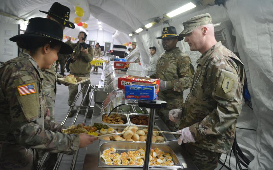 Command Sgt. Maj. Joshua C. Holthus, 1st Infantry Division Forward command sergeant major, serves Thanksgiving dinner to soldiers during a visit to Torun, Poland, on Nov. 27, 2019. Holthus and Col. Phil Brooks, 1st Infantry Division forward commander, were at Torun to visit the 3rd Battalion, 16th Field Artillery Regiment of the 2nd Armored Brigade Combat Team and bring a little holiday cheer to the deployed soldiers.