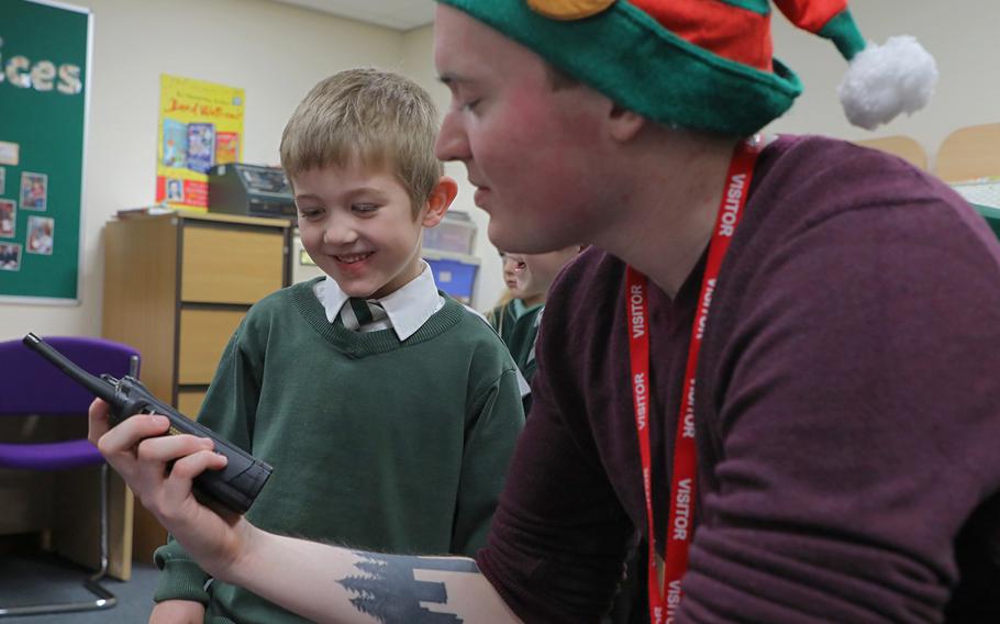 Jamie Liles, 5, talks to Santa over a handheld radio held by Troy Knoke, a volunteer from the 48th Communications Squadron on Dec. 13, 2019, at Great Heath Academy in Mildenhall, England. 
