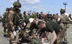 In this photo taken from video released by the Russian Defense Ministry on Friday, May 20, 2022, Russian servicemen frisk Ukrainian servicemen after they leave the besieged Azovstal steel plant in Mariupol, in territory under the government of the Donetsk People's Republic, eastern Ukraine. 