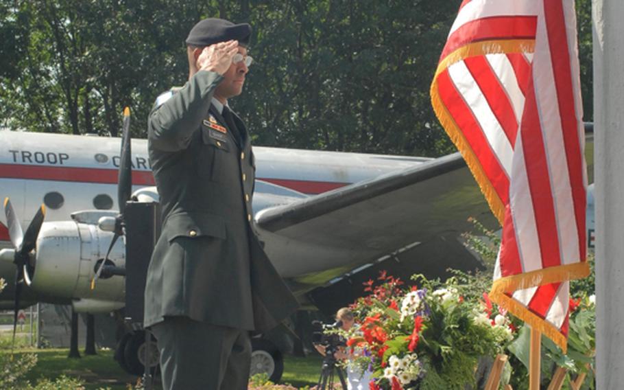 Sgt. 1st Class Jeffrey Guyot from Headquarters and Headquarters Detachment, U.S. Army Garrison Wiesbaden, salutes the American flag during a Berlin Airlift ceremony near Frankfurt, Germany, on Thursday.