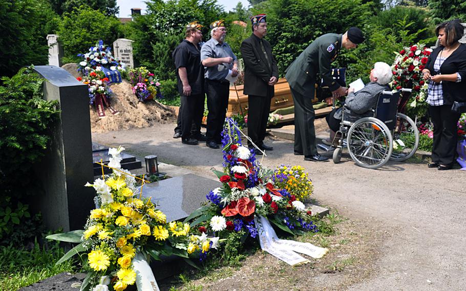 Chaplain (Capt.) Daniel Wheat pays his respects to Erika Lopez, at the funeral for Erika’s husband Al Lopez, who was buried Friday in Bamberg cemetery. Lopez, who died at age 82, was a retired Army master sergeant who decided to stay overseas. At right is his daughter Christina Lopez, and behind Wheat are members of the Europe chapter of the Veterans of Foreign Wars.
