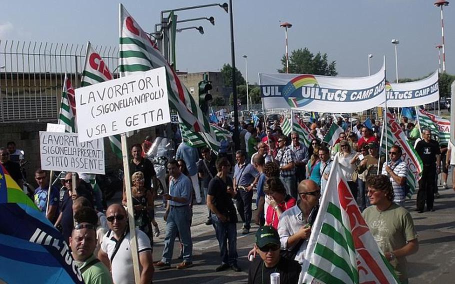 Hundreds of protesters from U.S. military installations around Italy gathered early Wednesday morning and marched to the front gate of the Capodichino base in Naples, Italy, to protest the February announcement of more than 90 job cuts affecting Italian employees in Naples and Sigonella.