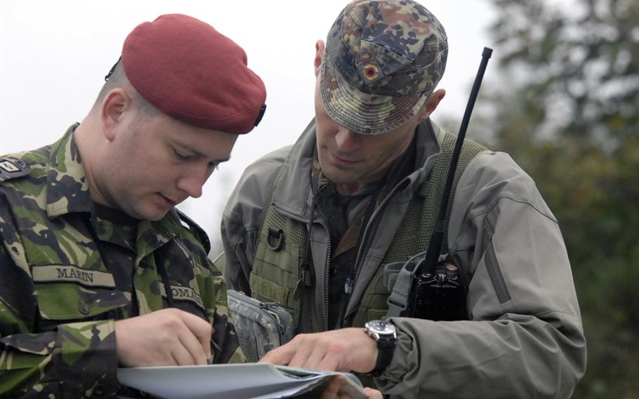 Romanian 1st Lt. Daniel Marin, left, and instructor Bernd Wellmann, a German air force major, check Marin&#39;s target coordinates before he calls in an airstrike during field training at the joint terminal attack controller course near Bann, Germany, on Sept. 28. Wellmann is with the U.S. Air Forces in Europe&#39;s Air Ground Operations School, which teaches the five-week course.