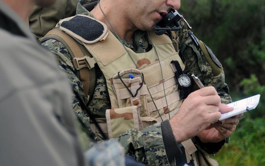 Instructor Bernd Wellmann, a German air force major, left, listens as  Sgt.Robert Alaugsic of the Croatian army calls in an airstrike during a joint terminal attack controller course near Bann, Germany, on Sept. 28. The five-week JTAC course is run by the USAFE Air Ground Operations School in Kaiserslautern.