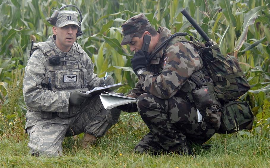 Staff Sgt. Rudolf Rot of the Slovenian armed forces calls in an airstrike during a joint terminal attack controller course near Bann, Germany, on Sept. 28, as instructor U.S. Air Force Capt. Jon Chango of the USAFE Air Ground Operations School listens in.