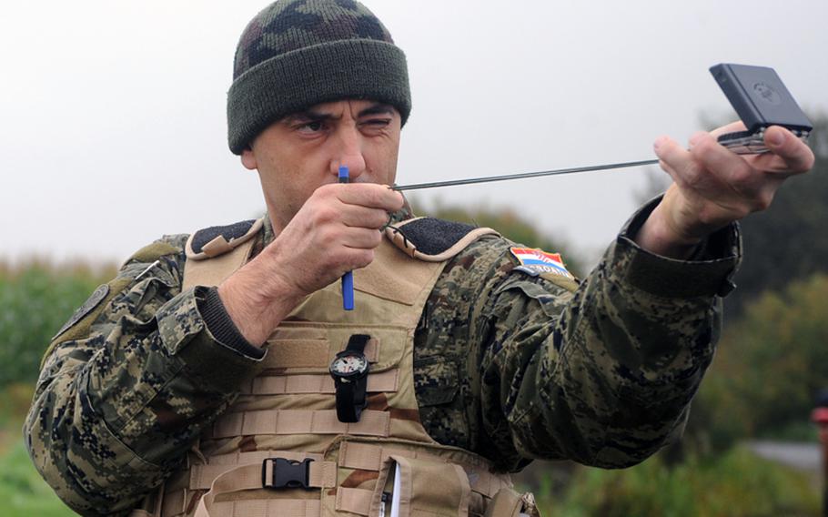 Croatian army Sgt. Robert Alaugsic takes a compass reading as he scouts a target during field training at the joint terminal attack controller course near Bann, Germany, on Sept. 28.