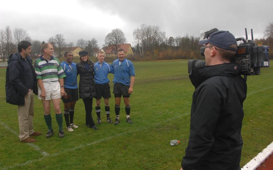 An ESPN cameraman films, from left, ESPN SportsCenter anchor Josh Elliot and Illesheim rugby team coach David McNaughten, team member Capt. Cheffren Canady, SportsCenter anchor Hannah Storm, and rugby team members Capt. Matthew Green, and Lt. Col. Vincent Torza on Sunday in Grafenwohr. The SportsCenter anchors are filming in advance of a Veteran's Day live broadcast from Grafenwohr, which will air from 3 p.m. to 9 p.m. Central Europe time on Thursday.