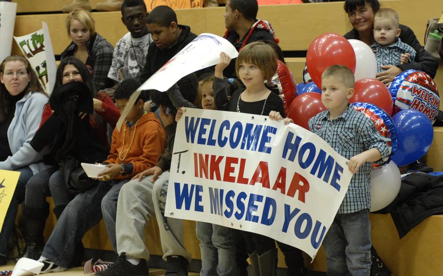 Lucina Inkelaar, 9, and her brother Matthew, 4, hold up a sign welcoming their father, Staff Sgt. Toric Inkelaar, back to Germany.  Inkelaar was among 96 1st Armored Division advance party soldiers who returned to Wiesbaden Tuesday night following a yearlong deployment to Iraq.