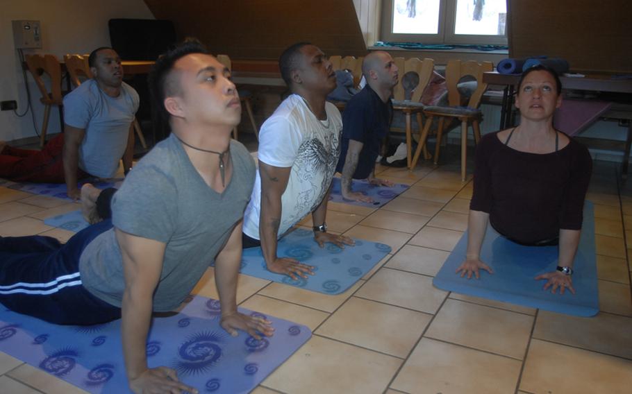 From left: Staff Sgt. Lincoln Manning, in background, 30, of New York; Sgt. Mark Coloma, 28, of Honolulu; Sgt. 1st Class Milton Johnson, 36, of Chicago and Staff Sgt. Neil Kessler, 32, of Albany, N.Y., learn yoga with the help of instructor Sarah Brown near Grafenwoehr, Germany on Wednesday.