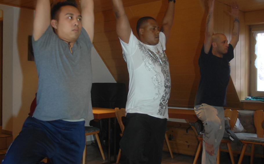 From left: Sgt. Mark Coloma, 28, of Honolulu; Sgt. 1st Class Milton Johnson, 36, of Chicago and Staff Sgt. Neil Kessler, 32, of Albany, N.Y., learn yoga Wednesday near the base at Grafenwoehr, Germany.