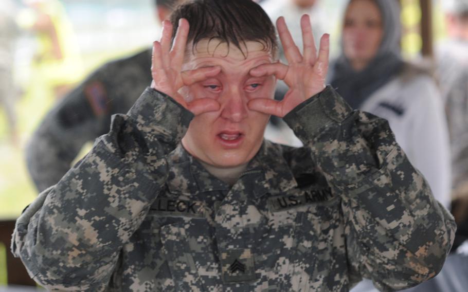 Sgt. Michael Selleck tries to clear his eyes after being hit with pepper spray.