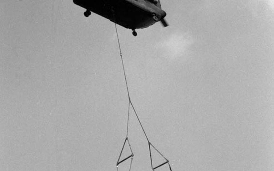 In August, 1981, an Army CH-47 Chinook helicopter of the 295th Aviation Co at Coleman Barracks in Mannheim, Germany, lifts another Chinook belonging to the 205th Aviation Co at Finthen Army Air Field. The copters were on their way from Mannheim to Ramstein Air Base, where the stripped-down craft from Finthen was to be loaded aboard a C-5 Galaxy for a flight to the United States to be rebuilt. Before the flight, the 205th&#39;s craft was reduced in weight from its normal 21,000 pounds to 11,000 by removing its fore and aft transmissions, rotors and engines.