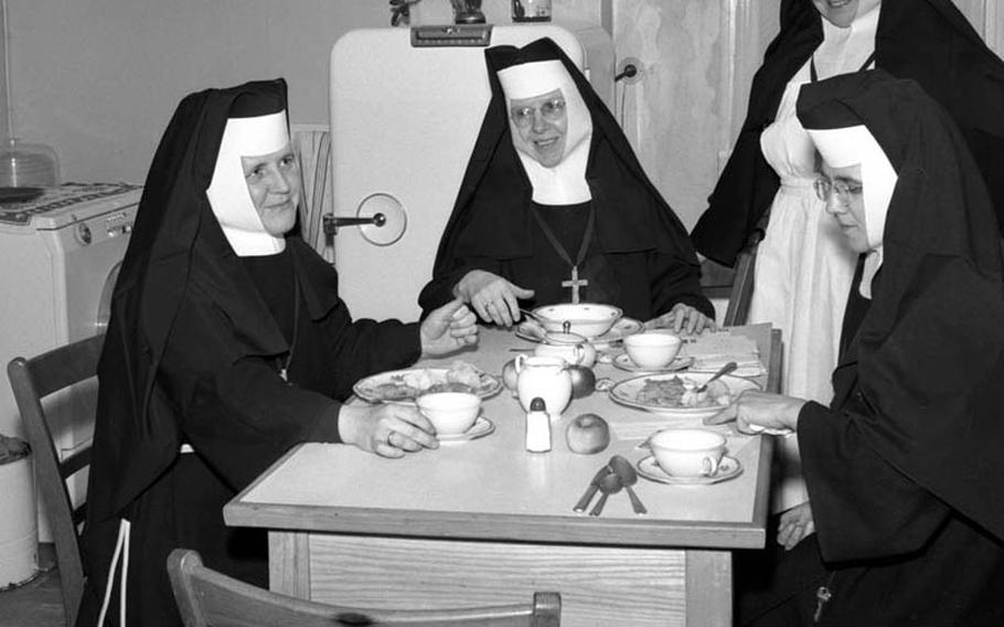 In December, 1957, four Felician Sisters from Detroit gather for dinner in the kitchen of the Marianum Children&#39;s Home for refugee children, which they established the year before at Carlsberg, Germany. In addition to caring for the dozens of young residents, accomplished with help from local groups and soldiers from the 34th AAA Brigade in Mannheim, the nuns also taught catechism to American children at Mannhein, Sembach and Heidelberg&#39;s Patrick Henry Village.