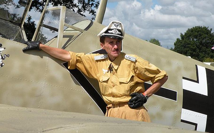 A re-enactor poses in front of a German World War II aircraft at the War and Peace show on July 22.
