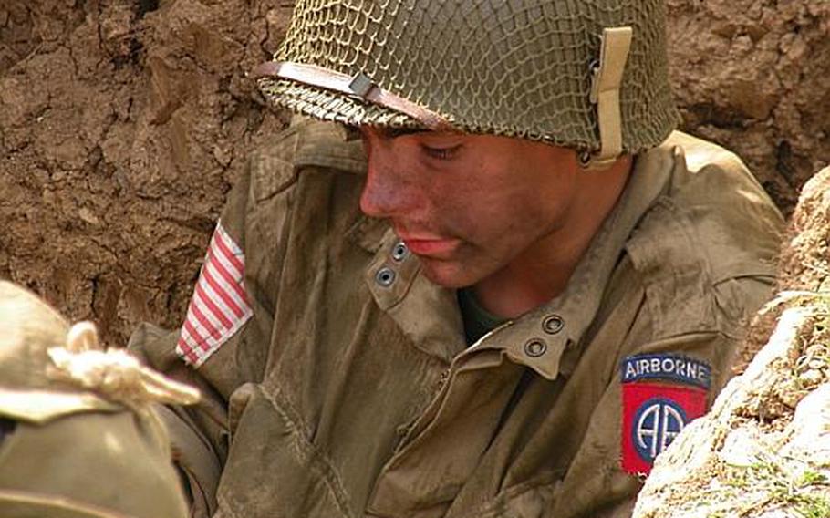 Thomas Isted spends his afternoon at the War and Peace show in a foxhole wearing U.S. Army attire from World War II. Isted, 16, has been with the All American Pathfinders living-history group for about a year. 
