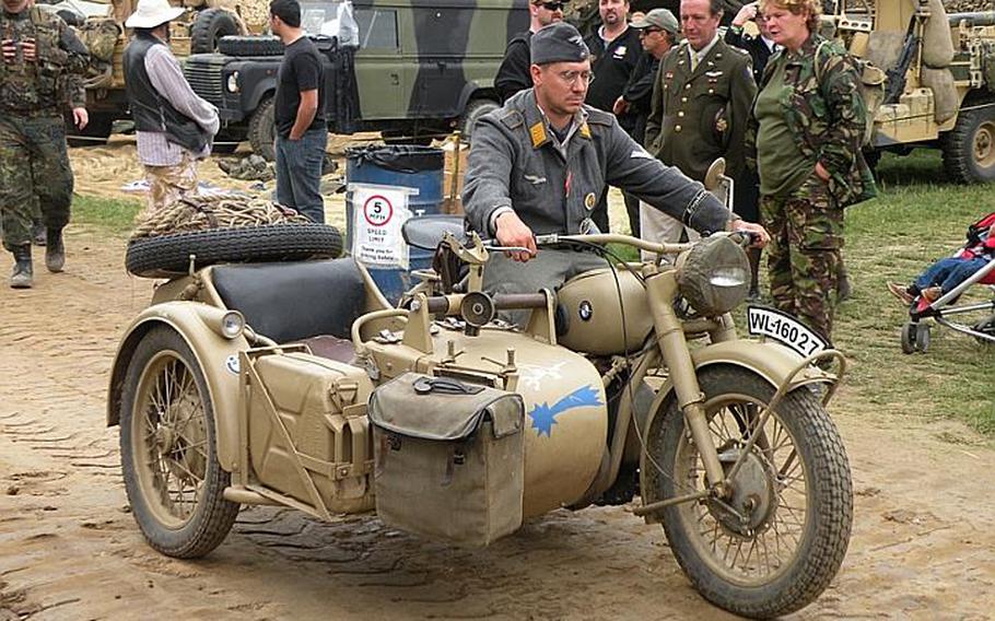 A re-enactor dressed as a member of the German forces from World War II rides his vintage BMW motorcycle with sidecar, at the War and Peace show.
