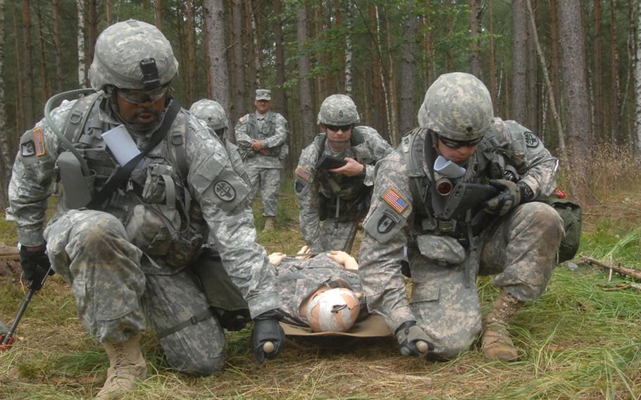 Cpl. Grady Clark, left, a medical supply specialist with the U.S. Army Medical Materiel Center in Pirmasens, Germany, prepares to lead soldiers along an obstacle course as part of training for the Expert Field Medical Badge at the Grafenwöhr Training Area. More than 300 candidates from a spectrum of medical occupations are training this week for the coveted badge; testing begins Aug. 8.