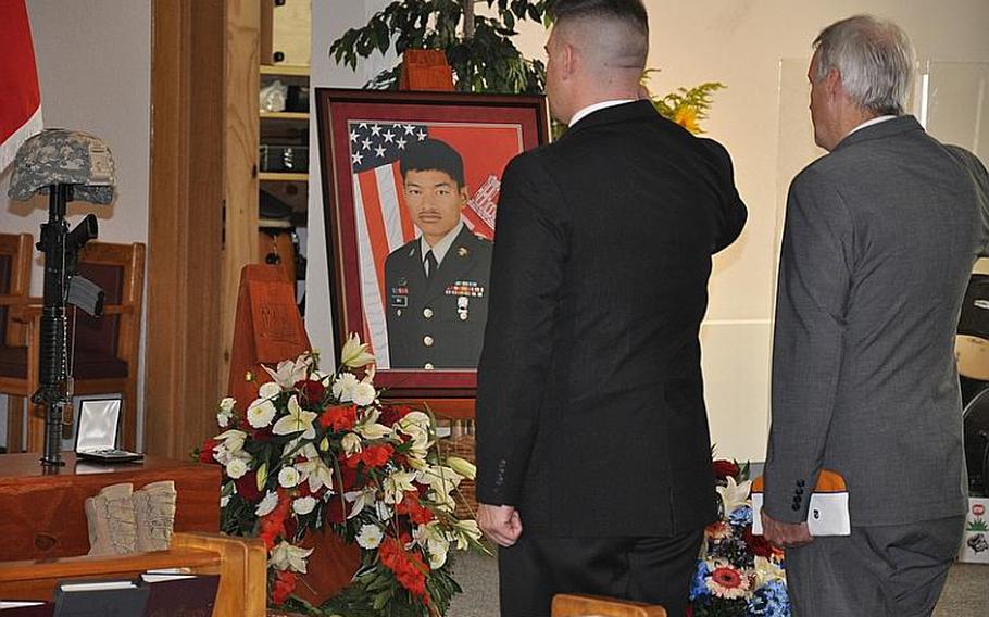 Sam Biornstad, left, a 54th Engineer Battalion veteran, and Mike Sowinski, a Veterans of Foreign Wars member, pay their respects to Sgt. Barun Rai on Friday at the Bamberg (Germany) Community Chapel on Warner Barracks. Rai was killed Aug. 3, 2011, in a vehicle rollover accident in Afghanistan. 
Dan Blottenberger/Stars and Stripes