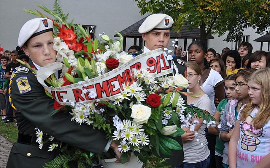 Cadets Nicholas Zurcher, a junior, and Daniel Riojas, a senior, carry a bouquet of flowers at the Bamberg Middle/High School Friday during a 9-11 remembrance ceremony.