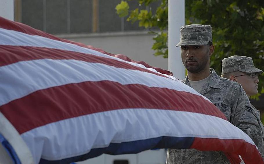 Senior Airman Bryant Lanier, from Springfield, Mass., folds the American Flag during a retreat ceremony to honor first responders on the 10th anniversary of Sept. 11, 2001. Lanier is assigned to the 48th Airspace Medicine Squadron at RAF Lakenheath, England.
