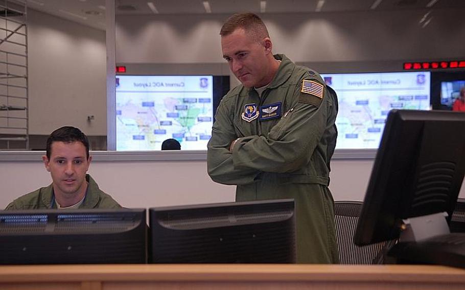 Maj. Christopher Breffitt, left, and Lt. Col. Matthew Barker work side-by-side in the new 603rd Air and Space Operations Center at Ramstein Air Base, Germany. Barker was formerly the deputy chief of combat operations for the 617th Air and Space Operations Center. Its role, to help 17th Air Force with air operations in Africa, was rolled into the 603rd recently as part of cost-savings directed by the Pentagon.