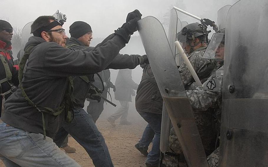 Soldiers with the 1st Battalion, 4th Infantry Regiment play the part of rioters during a Thursday civil disturbance simulation for soldiers preparing to deploy as NATO peacekeepers in Kosovo. The rotation, held at the Joint Multinational Readiness Center in Hohenfels, Germany, sought to mimic recent events in Kosovo, where ethnic Serbs created makeshift roadblocks to hinder the country’s ethnic Albanian leadership.