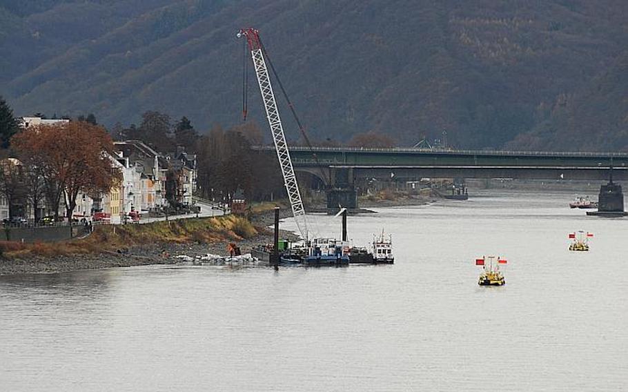 Workers began the task Dec. 4, 2011, of defusing a 4,000 pound bomb, dropped during World War II,  in Koblenz, Germany. Workers built sandbags around the bomb (pictured with the crane) to drain the water surrounding it. The flags mark an area where an American bomb and a grenade also were found recently in the Rhine River.