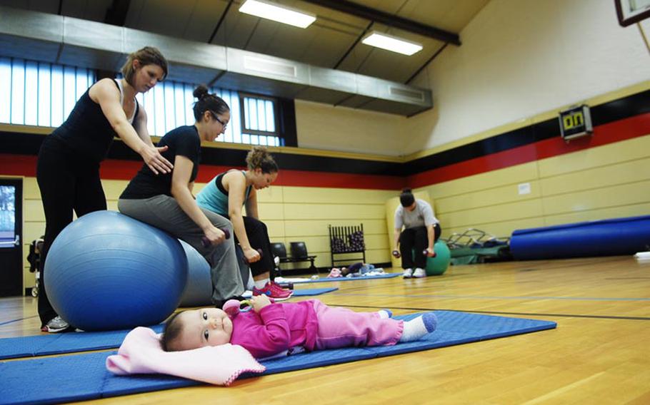 Amy Robitschek instructs Melissa Van Hausen how to properly sit on an exercise ball during a recent Binkies and Babes class at the Landstuhl Regional Medical Center fitness center in Germany. Van Hausen's 6-month-old baby was content to recline on a gym mat during the class. Binkies and Babes is one of several new classes the Army is offering in the Kaiserslautern area for parents and children.