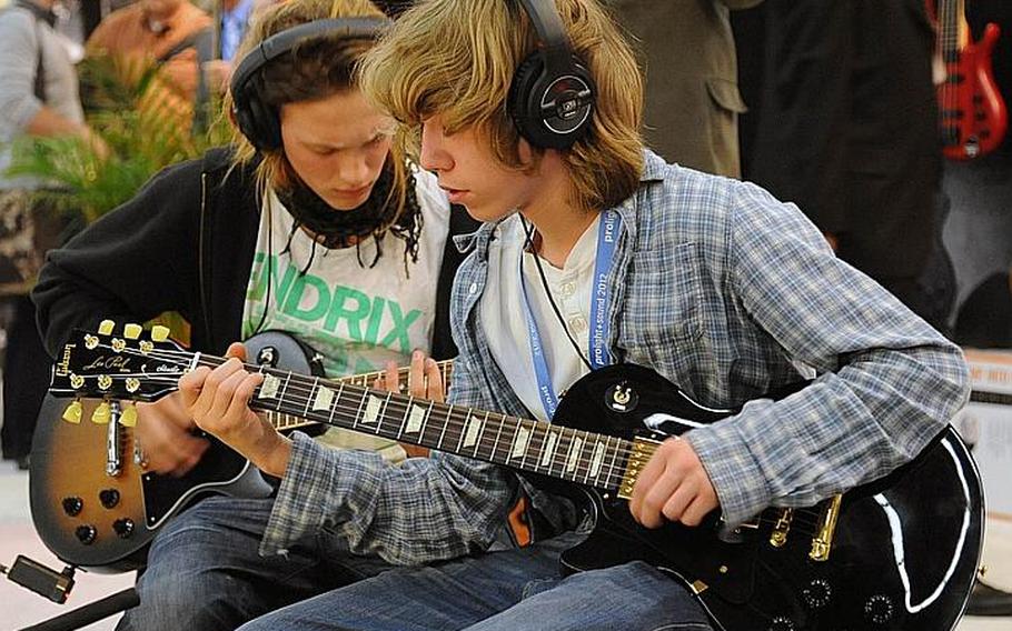 A couple of musicians try out some Gibson guitars March 21, 2012, at the Musikmesse international music fair in Frankfurt, Germany. The fair is open to the general public at the fairgrounds (Messe) in Frankfurt on March 24, 2012. Admission is 20 euros, and tickets can be bought online.