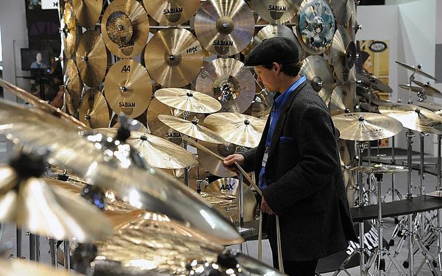 A visitor to the Musikmesse international music fair in Frankfurt, Germany, tests a cymbal at the Sabian stand. The event, held at the city's fairgrounds, opens to the general public on March 24, 2012. Admission is 20 euros, and tickets can be bought online.