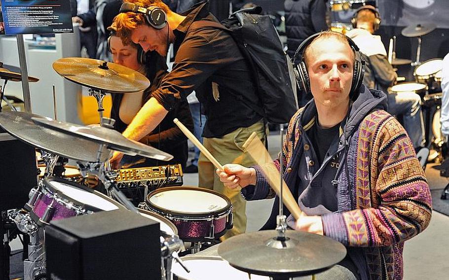 One man at the Musikmesse international music fair in Frankfurt tries a drum set that can be played in an almost-silent mode, but can be heard through earphones and fed directly into a recording device.