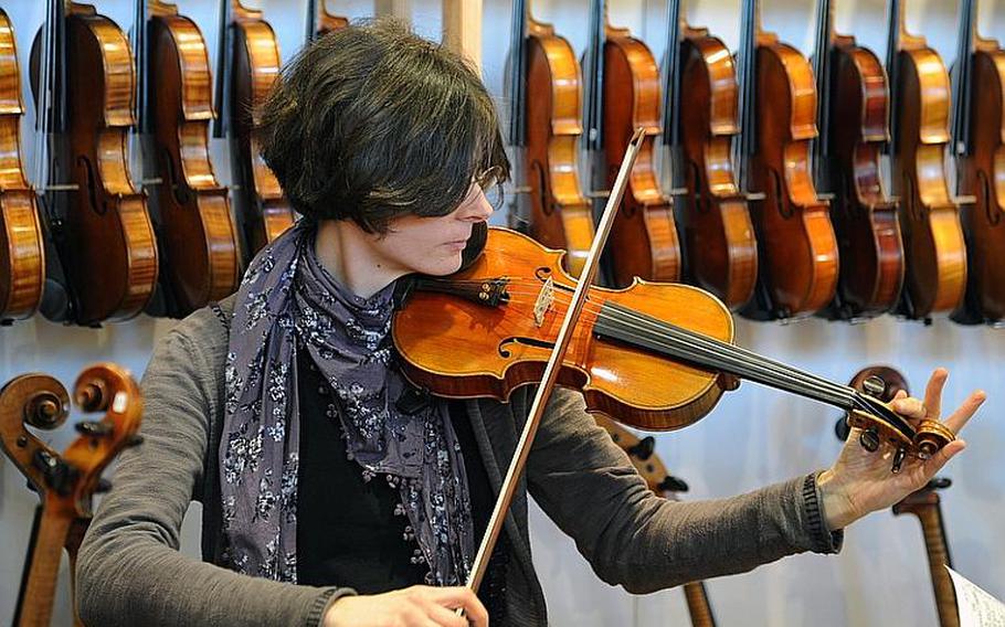 A visitor to the Musikmesse international music fair in Frankfurt, Germany, tests the sound of a violin at the Wieczorek & Kühne stand. About 1,500 exhibitors are on hand for the fair, which is advertised as the largest of its kind in the world. It opens its doors to the general public at the fairgrounds (Messe) in Frankfurt on March 24, 2012.
