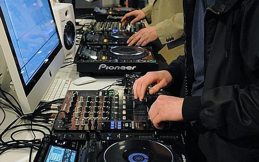 A visitor to the Musikmesse international music fair in Frankfurt, Germany, tries out a disk jockey mixing board at the Pioneer stand. About 1,500 exhibitors are offering all things musical, from traditional instruments to modern digital electronics.