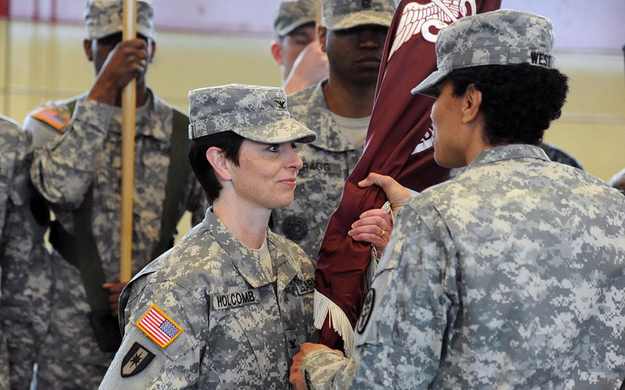 Col. Barbara R. Holcomb, the incoming commander of the Landstuhl Regional Medical Center, left, takes the LRMC colors from Brig. Gen. Nadja Y. West, commander of the Europe Regional Medical Command, at a change of command ceremony in Landstuhl, Germany, Thursday. Holcomb took command from Col. Jeffrey B. Clark, who is slated to replace West at ERMC.