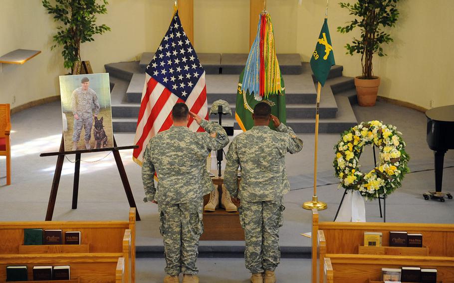 Two soldiers give a final salute to Staff Sgt. Dick A. Lee Jr. at the end of the memorial ceremony for the 529th Military Police Company soldier who was killed in Afghanistan on April 26, 2012. Lee&#39;s working dog Fibi was also killed when their vehicle was hit by a roadside bomb in Ghazni provice.