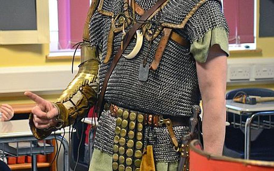 Re-enactor John Hyland, playing the part of a Roman soldier known as Titus Aelius Karus, speaks to Lakenheath Middle School students during U.K. Day, held Friday at RAF Feltwell, England. Hyland said his outfit is similar to the uniform once worn by a Roman infantry soldier.
