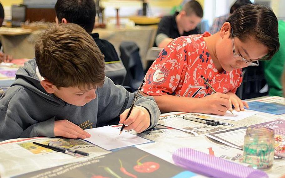 Sixth-grades Shaun Freeman, left, and Kylar Cade sketch a design for a stained-glass piece of art during Lakenheath Middle School?s sixth annual U.K. Day, held Friday at RAF Feltwell, England.